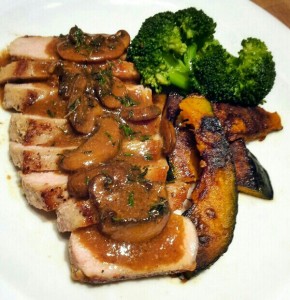 pan seared pork chop sliced and topped with a mushroom marsala sauce, broccoli, and caramelized zucchini