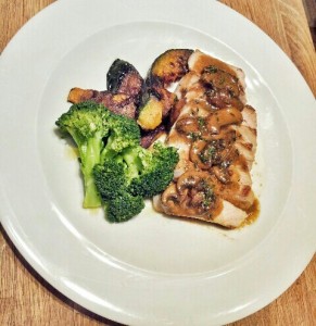 pan seared pork chop sliced and topped with a mushroom wine sauce, broccoli, and caramelized zucchini