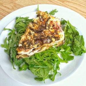 savoury eggplant cheesecake on a bed of arugula drizzled with zaatar oil